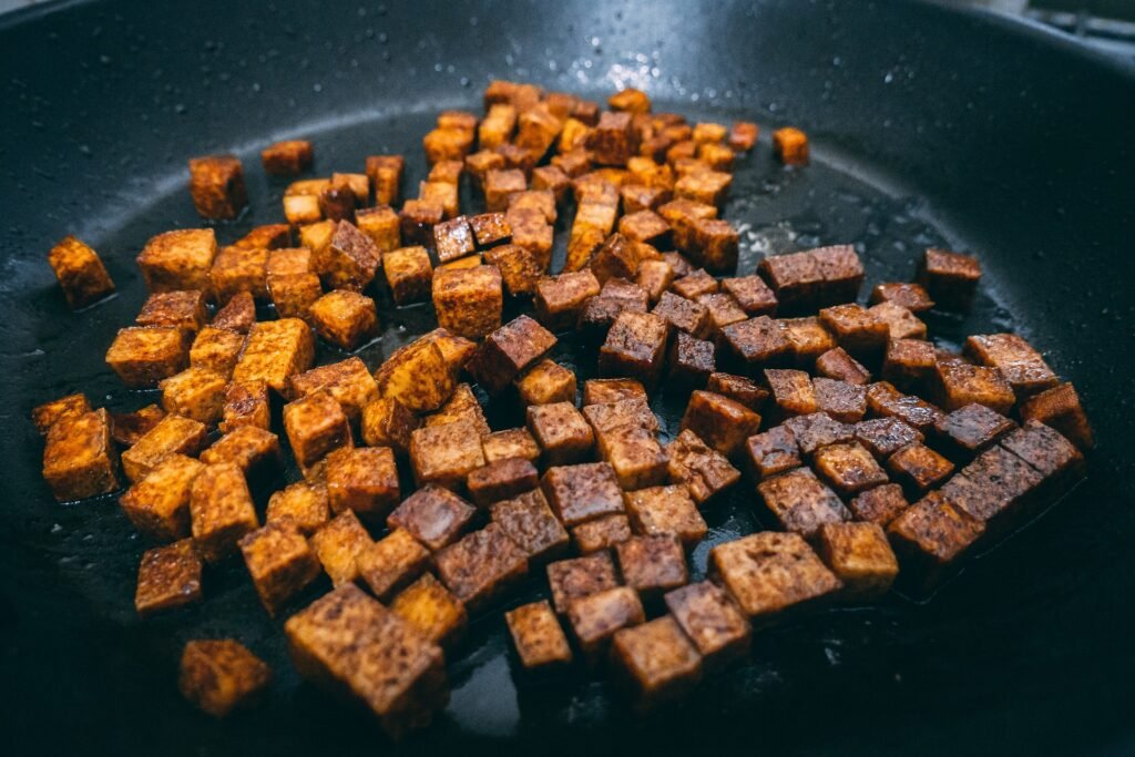 Cubes de tempeh dorés en train de cuire à la poêle.