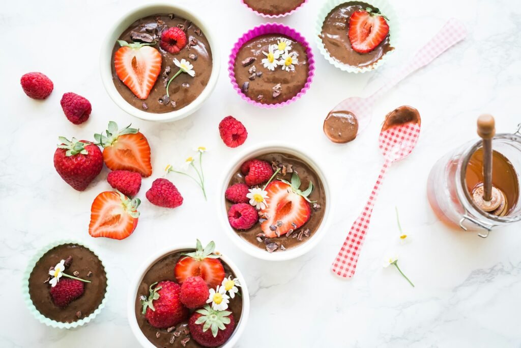 Mousse au chocolat végétarienne accompagnée de fraises et framboises pour un dessert équilibré.