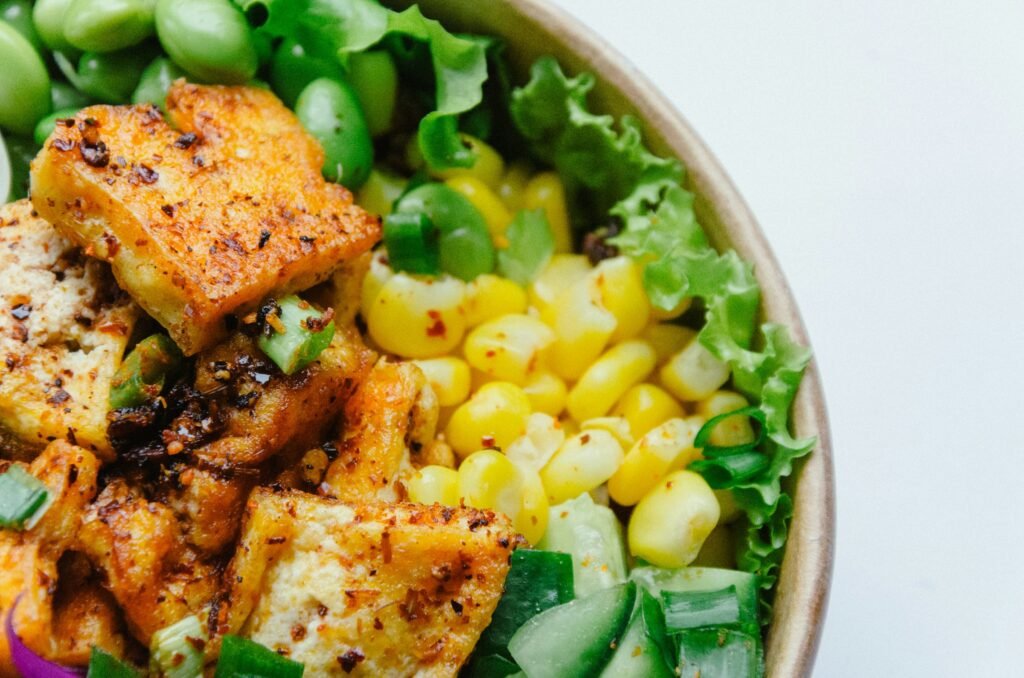 Bol gourmand avec maïs, edamame, tofu mariné et autres produits à base de soja.
