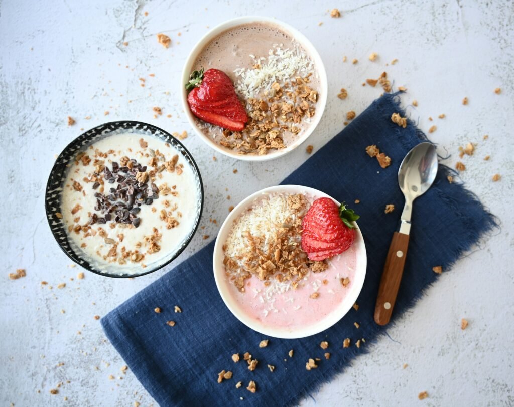 Bols de smoothie bowl garnis de granola, réalisés avec des alternatives végétales aux produits laitiers.