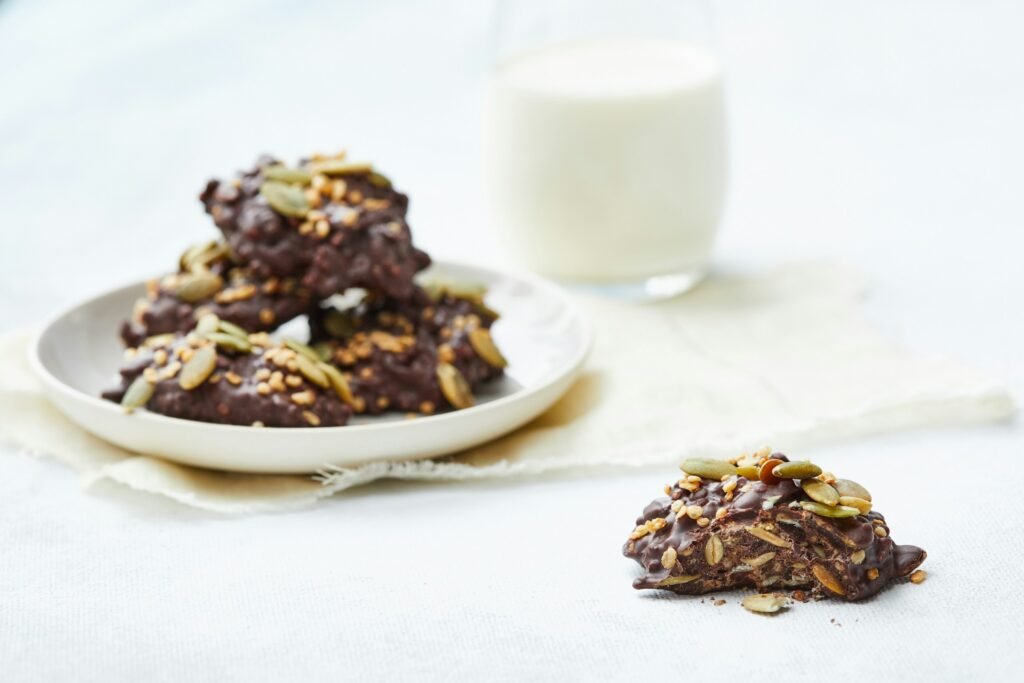 Biscuits au chocolat et graines, accompagnés de lait végétal, une alternative aux produits laitiers.