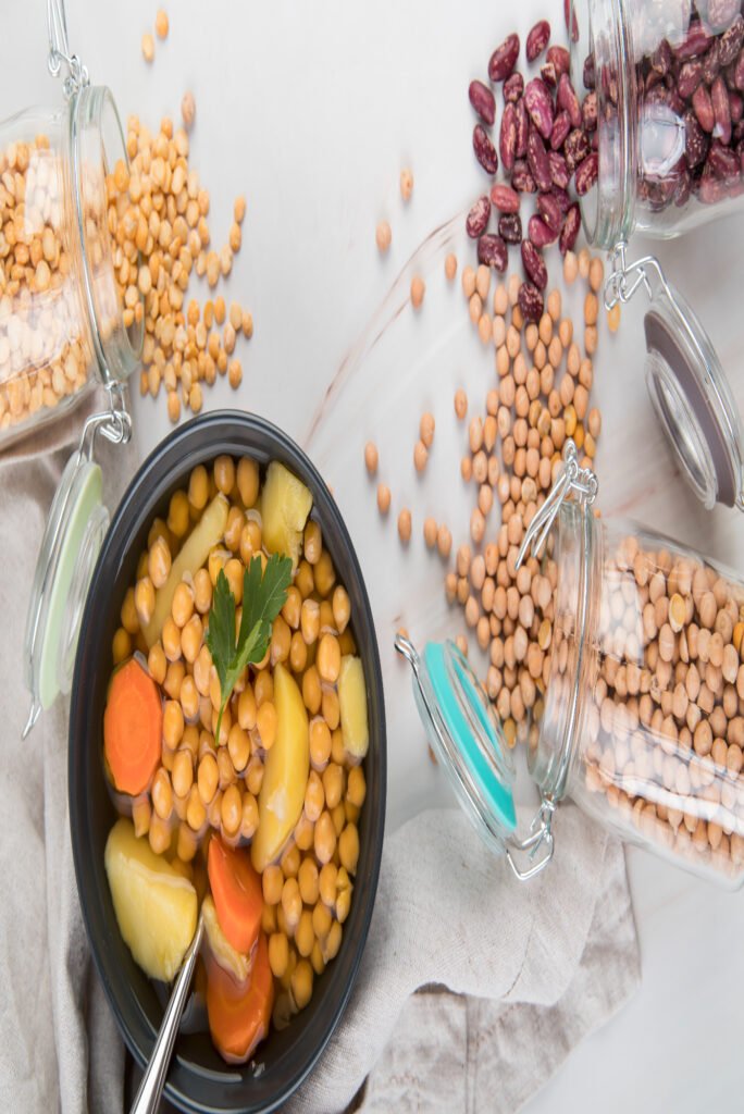 Enfants et le soja : pois chiches et légumes dans un bol avec bocaux en arrière-plan.
