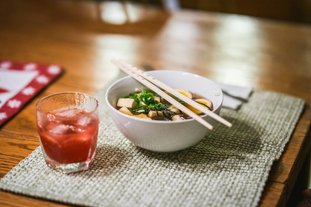 Bol de soupe miso avec tofu, algues et oignons verts sur une table.